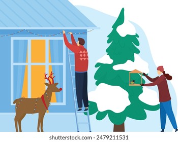 Man blue ladder installing Christmas lights house facade, snowcovered roof. Woman winter coat feeding birdhouse, evergreen tree snow. Reindeer decor light strand near festive home. Decorating home