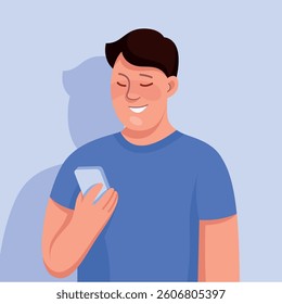 Man in a blue shirt standing and holding a mobile phone in his hand. He is looking at the phone, possibly checking messages or browsing the internet.