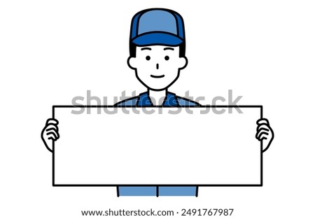Man in blue work clothes holding a horizontal placard