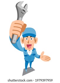 A man in blue work clothes who raises a spanner and proposes