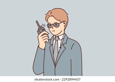 Man bodyguard use walkie-talkie to inform security service about arrival of guest or dangerous situation. Guy working as bodyguard wear formal suit to take care of safety important person or business