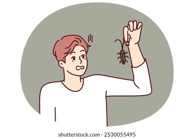 Hombre con bicho en la mano, mira a un insecto y se asusta sufriendo de aracnofobia y asco. El tipo encontró un insecto y quiere deshacerse de la plaga llamando al servicio para el tratamiento químico de los insectos