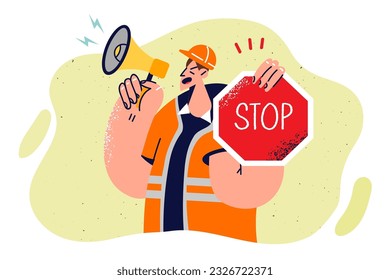 Man builder with stops sign shouts into megaphone warning people of danger due to road repair or construction. Guy road worker stops movement of cars and urges to slow down in dangerous area