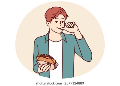 Man with burger licks fingers and enjoys reception of fast food bought in street restaurant or ordered for delivery. Smiling guy holding tasty cheese burger while eating sandwich with cutlet