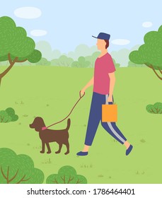 Man in cap walks dog on leash through park or forest. A man carries a bag or paper bag. Walking pets in nature, outside the city. Clean up after pet. Green spaces. Guy walking with brown dog