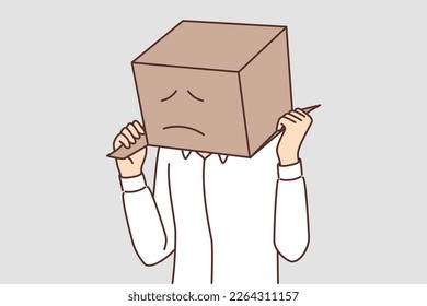 Man with cardboard box on head with painted sad face. Sad guy in white shirt hides head behind parcel for concept of problems with courier company or delivery service
