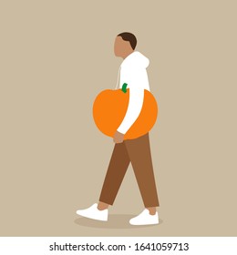 A man carries a big pumpkin