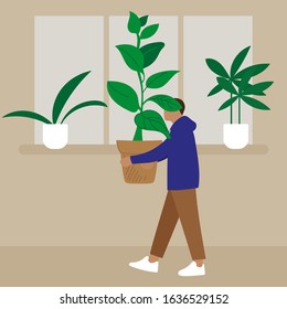 
A man carries in his hands a pot of plants