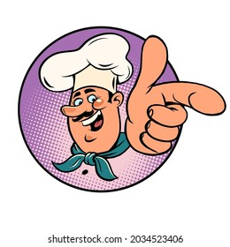 Man chef in a white cap. Smiling face. Professional points a finger