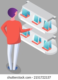 Man chooses smartphone at exhibition. Male character looking at mobile phones and tablets near promotion stand in shopping mall. Presentation of new technologies, gadgets, electronic devices at rack