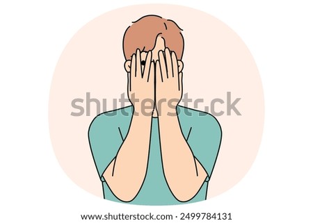 Man closes eyes with hands and peeps, feeling excited in anticipation of surprise or panic after receiving threats. Guy feels insecure and panic, trying to hide from problems that have arisen.