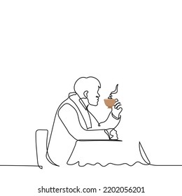 man in a coat and scarf sits at a table in a street cafe (terrace) with a steaming cup of hot tea - one line drawing vector. concept keep warm in autumn or winter with hot drinks