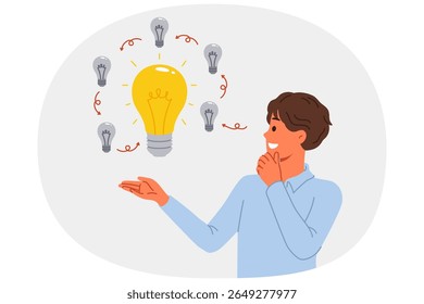 Man comes up with innovative idea, allows to get investments on crowdfunding platform, standing near light bulbs. Concept development and evolution of ideas to obtain ideal option.