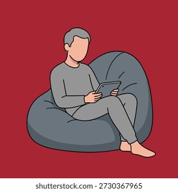 A man in comfortable clothing is sitting on a bean bag chair, engrossed in a tablet device.