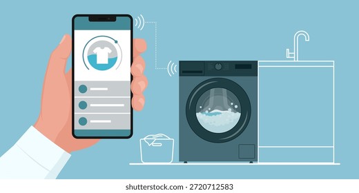 Homem conectando seu smartphone a uma máquina de lavar inteligente: automação doméstica e conceito de aparelhos inteligentes
