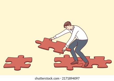 Man connecting jigsaw puzzle pieces making way or road to walk. Male find solution solving problem answering question. Flat vector illustration. 