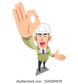 A man in a construction shop wearing a helmet showing OK sign with his hand