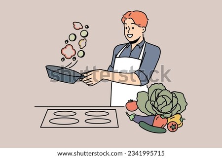 Man cook stands at stove and prepares romantic dinner of fried vegetables for beloved woman. Chef cook guy throws food on pan demonstrating skills of professional culinary specialist