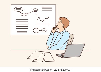 Man corporate manager happily looking at growing charts of increasing profits. Guy manager is sitting at table with laptop studying business data on increase in number of customers