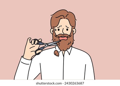 Man cuts off own beard with scissors because of appearance requirements at new job. Adult depressed guy is stressed due to need to get rid of beard or lack of money to go to barbershop. 