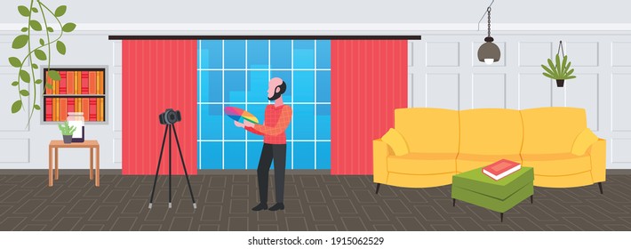 man designer holding colored palette samples blogger recording online video with digital camera on tripod social network blogging concept modern design studio interior full length horizontal vector