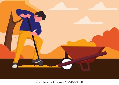 Man digging hole on the ground.Farmer digging hold on the ground. The cart with earth, autumn landscape, harvesting