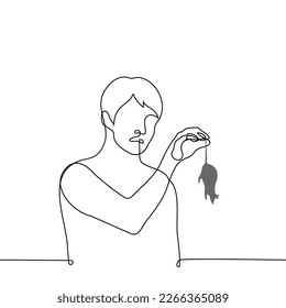 man in disgust holds a rat by the tail - one line drawing vector. concept to catch a rat, dead rat