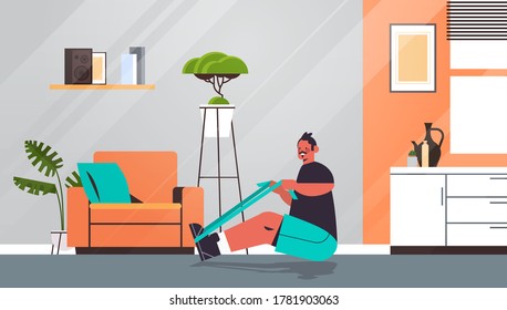 man doing exercises with resistance band at home guy having workout cardio fitness training healthy lifestyle sport concept living room interior full length vector illustration