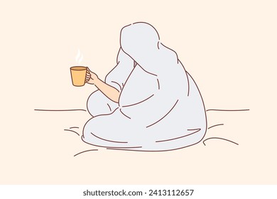 Man drinks coffee sitting on bed and wrapped in blanket to warm up after walk along winter street. Cup of hot coffee in hands of human enjoying comfort and energizing thanks to drink.