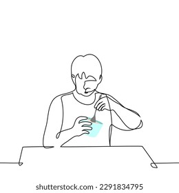 man eating ice cream from a plastic bucket with a spoon - one line drawing vector. concept eat sweets, night snack, sweet tooth
