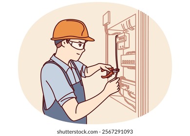 Man electrician repairs power shield and connects residential building or factory to electricity. Guy in electrician uniform repairs wiring standing near cabinet with power machines and wires