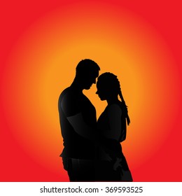 A man embracing his beloved woman in the sunset. Silhouettes.