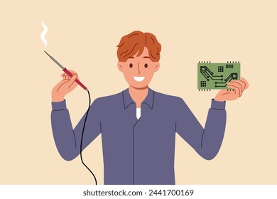 Man engineer with electronic circuit and power tool in hands rejoices at invention of new PCB for powerful computer. Designer guy invented electronic circuit smiles and looks at camera