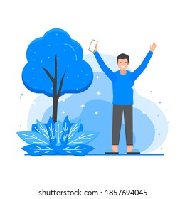 A man feels happy in the middle of nature and a tree whilte holding his smartphone and rise his hands up