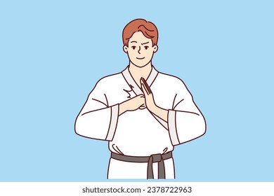 Man fighter in karate or taekwondo clothes makes welcoming gesture to invite opponent to start fight. Guy is interested in karate and studying self-defense techniques to maintain sports lifestyle