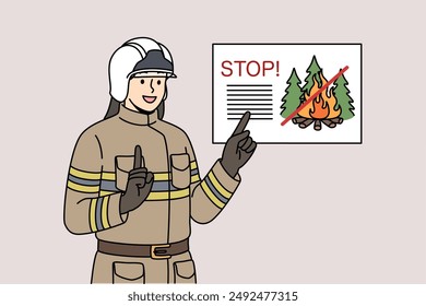 Man Feuerwehrmann erinnert an das Verbot, Feuer im Wald zu entzünden, in Arbeitsuniform zu stehen und Helm. Professioneller Feuerwehrmann lächelt aufgeregt, um nicht Feuer in Parks beim Gehen zu entfachen.