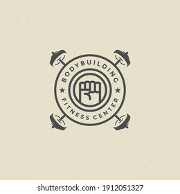 Man fist logo or badge vector illustration heavy barbells symbol silhouette. Retro typography fitness emblem design template or t-shirt print stamp.
