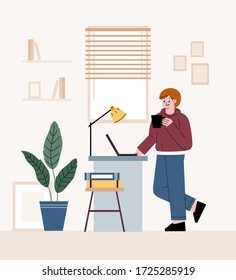 Man freelancer. Standing in front of a table and working on a laptop. Telecommuting at home.