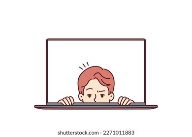 Man with frightened face looks out of laptop screen for concept of non-professional work on Internet and IT technologies. Frightened guy in laptop display looks at you in disbelief