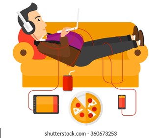 Man with gadgets lying on sofa.