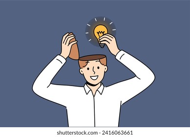 Man genius with new idea takes light bulb out of head after brainstorming and searching for opportunities to achieve success. Creative guy comes up with idea for marketing campaign for company