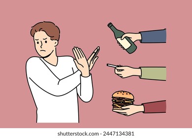 Man gives up bad habits, making forbidden gesture near hands with alcohol and cigarettes or fast food. Guy says stop bad habits to start healthy lifestyle and avoid loss of immunity