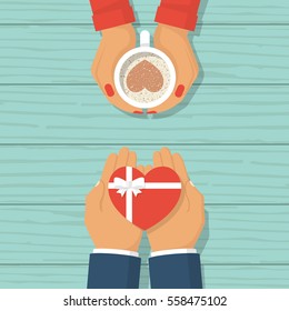 Man Gives A Gift On Valentine's Day. Loving Couple Male And Woman At Desk. Coffee With Chocolate Heart In Hands Of Female. Gift With A Ribbon In Form Of Heart. Vector Flat Design. Wooden Background.