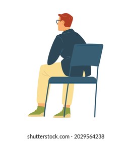 Man in glasses sits with back on chair in flat vector illustration isolated on white background. Male cartoon character is sitting in half-turn on blue chair, listening or watching with enthusiasm.