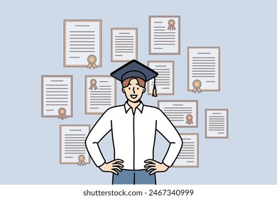 Man graduate stands in academic hat near wall with diplomas from advanced business courses. Guy is graduate and proud of good education and availability of documents confirming qualifications