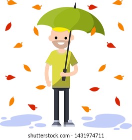 Man in green clothes holding umbrella. Orange and red leaves are falling. Protection from the weather, wind and autumn. Cartoon flat illustration. Blue puddles of water on the ground