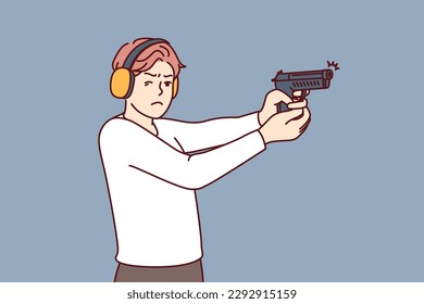 Mann mit Schusswaffenzügen, um zu lernen, wie man schießt und Sheriff oder Bodyguard wird. Guy in ballistischen Kopfhörern hält Schusswaffen und Punkte, die Ziel treffen während der Ausbildung in der Schießplatz 