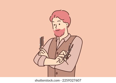 Man hairdresser working in beauty salon stands with arms crossed holding comb and scissors. Barbershop specialist guy confidently looks ahead deciding what hairstyle to make to visitor