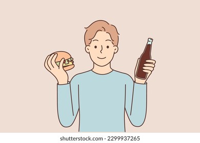 Man with hamburger and soda offers fast food snack or street restaurant with delicious sandwiches. Happy guy holding hamburger with beef cutlets ordered for delivery in American cuisine cafe