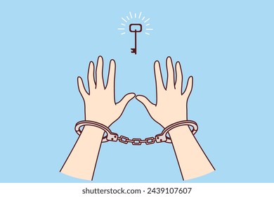 Man in handcuffs reaches for key, wanting freedom and independence, metaphor for solution to problem found. Prisoner sees chance for freedom after unjust court decision that ruined person life